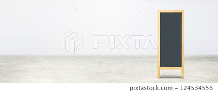 Blank blackboard on a concrete floor with a white wall. 124534556