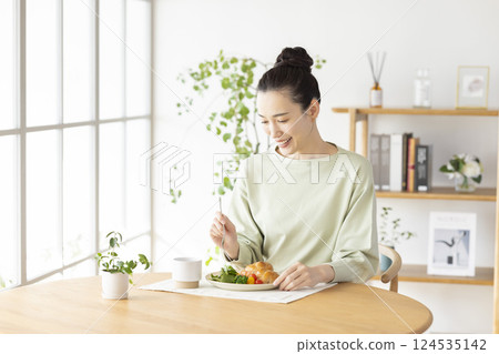 woman eating at home woman eating at home 124535142
