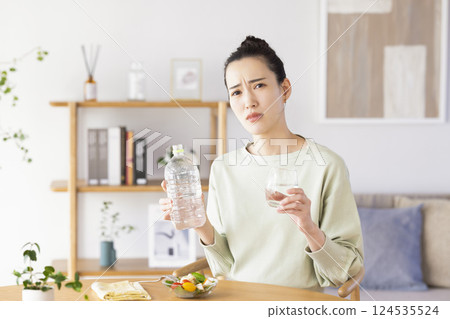 飲食：一位女性試圖喝大量的水 124535524