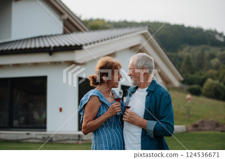 Happy senior couple enjoying glass of wine together at a family gathering. 124536671