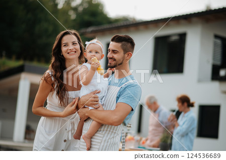 Portrait of young family during spring outdoor barbecue. 124536689