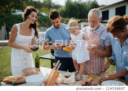 Three generations of family preparing food for a spring weekend barbecue. 124536697
