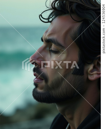 Pensive man by the ocean: introspective moment of solitude and reflection 124536904