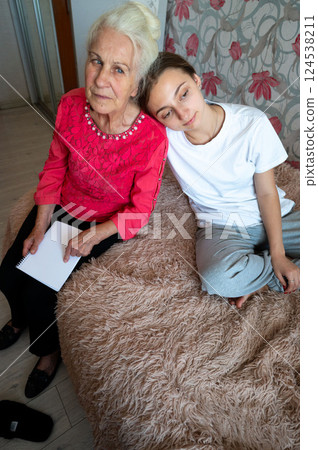 Bonding moments between generations in a cozy room adorned with floral patterns, capturing the warmth of shared stories and companionship on a serene afternoon Bonding moments between generations in a cozy room adorned with floral patterns, capturing the warmth of shared stories and companionship on a serene afternoon 124538211