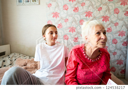 Cherished moments between generations in a cozy bedroom filled with memories and warmth during a sunny afternoon 124538217
