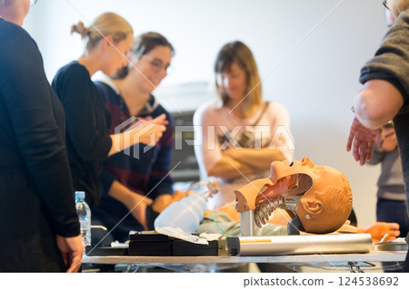 Medical doctor expert instructor displaying method of patient intubation on medical education training and workshop. Participants working in teams learning new medical procedures and techniques. 124538692
