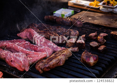 Some excellent pieces of Argentinian beef on a charcoal grill being prepared at open kitchen street food festival in Ljubljana, Slovenia Some excellent pieces of Argentinian beef on a charcoal grill being prepared at open kitchen street food festival in Ljubljana, Slovenia 124538822