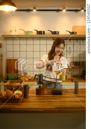Young woman pouring pouring freshly brewed coffee into a cup in the kitchen Young woman pouring pouring freshly brewed coffee into a cup in the kitchen 124540207