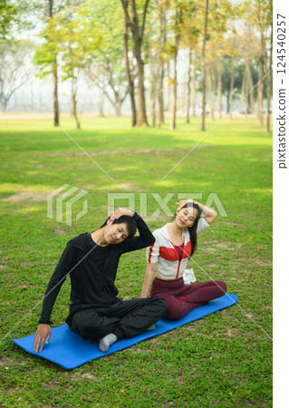 Athletic couple stretching while exercising together in a peaceful park. Healthy lifestyle concept 124540257