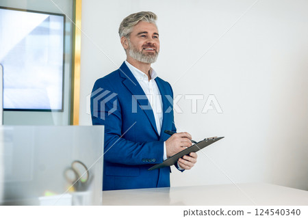 Entrepreneur in modern office presenting digital data on large screen 124540340