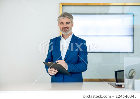 Manager in car showroom conducting online conference using professional display for dealership project 124540343