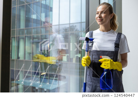 Female cleaner standing with the window washer in her hands 124540447