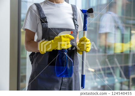 Female cleaner standing with the window washer in her hands Female cleaner standing with the window washer in her hands 124540455