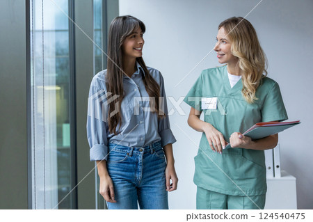 Female diagnostician in clinic talking with patient checking documents in hall 124540475