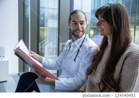Physician in medical office talking with patient during consultation discussing diagnosis Physician in medical office talking with patient during consultation discussing diagnosis 124540481