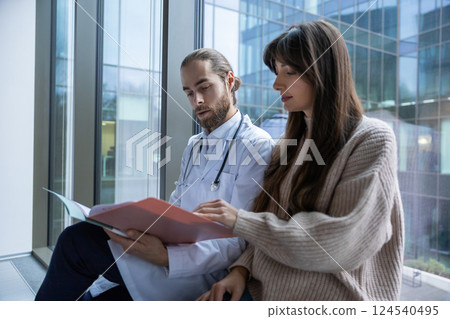 Physician in medical office talking with patient during consultation discussing diagnosis Physician in medical office talking with patient during consultation discussing diagnosis 124540495