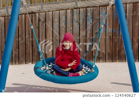 Caucasian smiling child of 8 9 years swinging on round seesaw 124540627