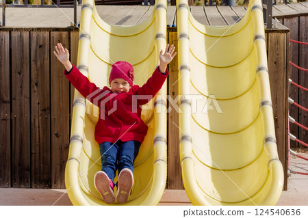 Caucasian happy child of eight nine years sliding with raised arms 124540636
