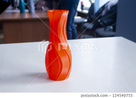 Object in the form of a vase of red color printed on a 3D printer. Three-dimensional model printed on a 3D printer from molten plastic of red color. Concept 3D Printing. FDM 3D Printing technology Object in the form of a vase of red color printed on a 3D printer. Three-dimensional model printed on a 3D printer from molten plastic of red color. Concept 3D Printing. FDM 3D Printing technology 124540755