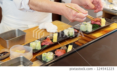 A Japanese chef plating food 124541223