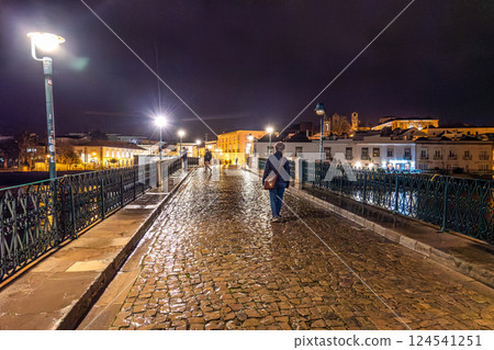 Tavira, Portugal - Feb 11, 2025: Roman bridge in Tavira, Algarve, Portugal at night. Ponte Romana bridge in Tavira town 124541251