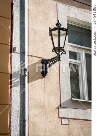 Vintage Street Lamp on Building Wall with Window and Pipe 124541860