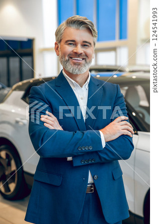Manager working with a buyer in the showroom showing available cars 124541993