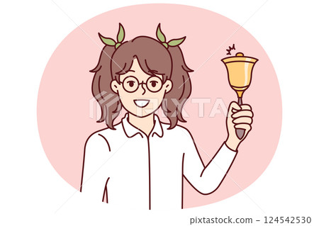Elementary school girl holds bell for start of academic year and looks at screen smiling 124542530