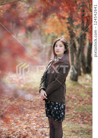 Portrait of a young Asian woman with autumn leaves Portrait of a young Asian woman with autumn leaves 124542641
