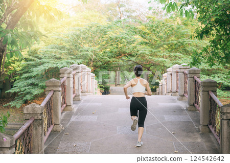 asian woman jogger, running over the bridge in public park. 124542642