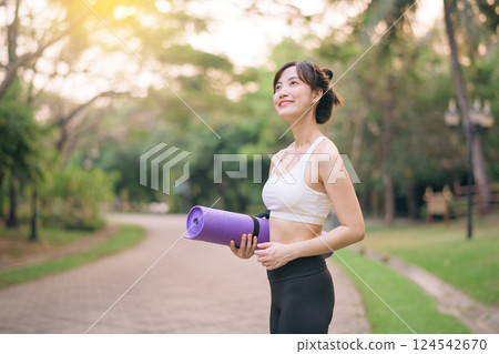 pretty fitness yoga woman in the park with yoga mat pretty fitness yoga woman in the park with yoga mat 124542670