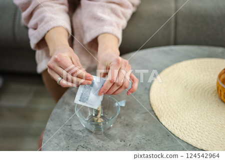 Woman pouring powder from sachet into glass bowl for preparing cosmetic mask Woman pouring powder from sachet into glass bowl for preparing cosmetic mask 124542964