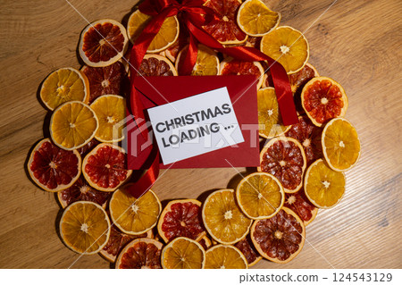 Greeting card with CHRISTMAS LOADING... text on handmade Christmas wreath. Festive mood new year celebration. Postcard decoration decor Greeting card with CHRISTMAS LOADING... text on handmade Christmas wreath. Festive mood new year celebration. Postcard decoration decor 124543129