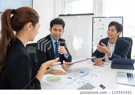 Team Collaboration and Business Strategy. A group discussing data-driven decisions in a modern office. Team Collaboration and Business Strategy. A group discussing data-driven decisions in a modern office. 124543581