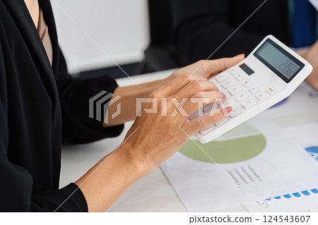 Financial Analysis and Calculation. A professional using a calculator to evaluate business data. 124543607