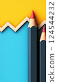 Two red and blue pencils against a bright yellow and blue backdrop 124544232
