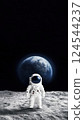 Astronaut standing on the Moon with distant Earth in black space 124544237