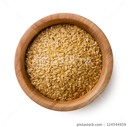 Flax seeds in a wooden plate close-up on a white. Top view Flax seeds in a wooden plate close-up on a white. Top view 124544939