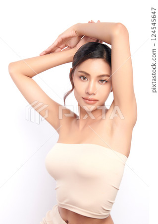 Beautiful Young Asian woman Raises her hands to Showcase clean and hygienic underarms Against a white background, Smooth armpit cleanliness and protection concept 124545647