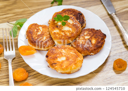 Appetizing cheese pancakes with a golden crust and a drop of honey Appetizing cheese pancakes with a golden crust and a drop of honey 124545710