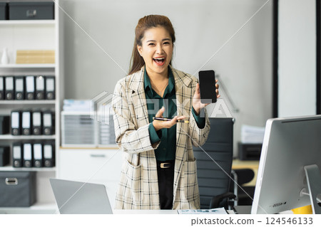Happy nusinesswoman holding a smartphone, happy smiling, getting bonus money. Happy nusinesswoman holding a smartphone, happy smiling, getting bonus money. 124546133