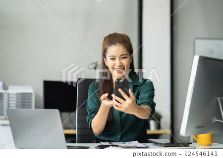 Happy businesswoman having fun social media doing live streaming using smartphone or laptop during free time. 124546141