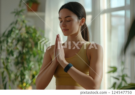 Young Woman Practicing Mindfulness and Meditation in Bright Indoor Space Surrounded by Plants Young Woman Practicing Mindfulness and Meditation in Bright Indoor Space Surrounded by Plants 124547750