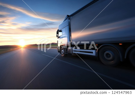 Side View of Freight Truck Driving Through Scenic Landscape at Sunset 124547963