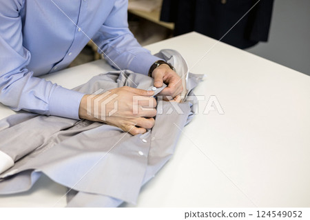 tailor in shirt is working at a table 124549052