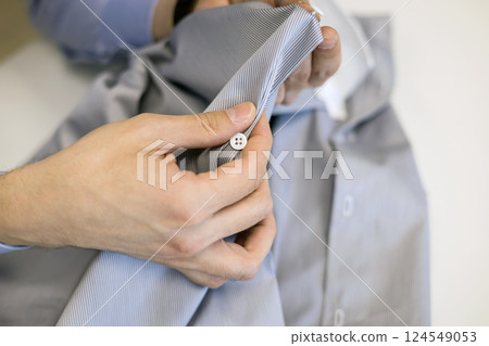 tailor concentrated on sewing buttons, close-up shot 124549053