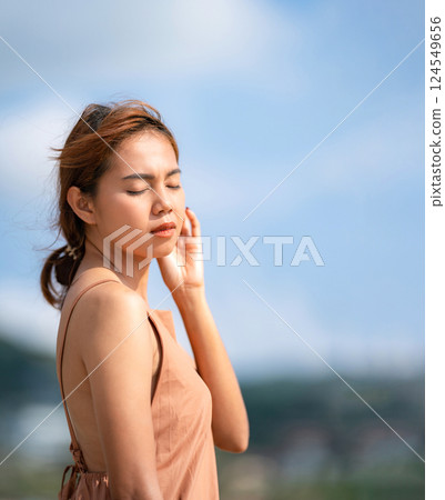 Beautiful Relaxed Thai Woman poses on the beach in the sunlight  with happiness and relaxation. Beautiful Relaxed Thai Woman poses on the beach in the sunlight  with happiness and relaxation. 124549656