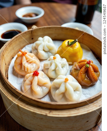 Assorted asian dumplings in bamboo steamer with dipping sauce on wooden table 124549687
