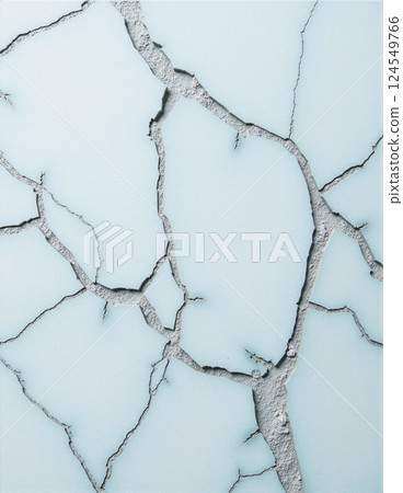 Cracked surface on light blue background with intricate fractures and textures 124549766