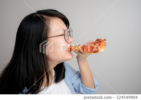 Happy glasses Asian young woman eat Pizza on white background. Happy glasses Asian young woman eat Pizza on white background. 124549904